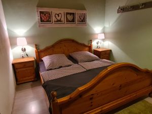 Schlafzimmer 1/ Elternschlafzimmer Schlafzimmer mit Doppelbett, zweitürigem Schrank, zwei Nachttischen und Garderobe. Zum Schlafzimmer gehört eine separate Toilette mit Waschbecken.