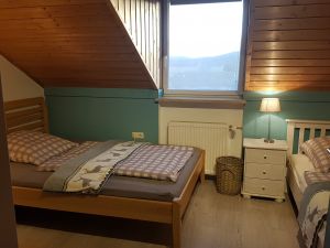 Schlafzimmer 2/ Kinderschlafzimmer Schlafzimmer mit zwei Einzelbetten, Schrank und Tisch. Zum Schlafzimmer gehört eine separate Toilette mit Waschbecken.