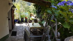 Terrasse Schattig unter Weinpergola, sonnig nahe am Geländer, Blick von Gasse oben, Eingangstür links