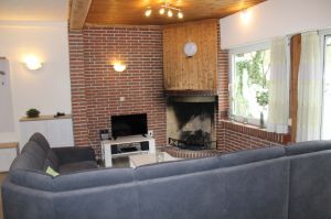 Die gemütliche Sitzecke im Wohnbereich mit dem elektrischen Kamin und Blick ins Grüne.