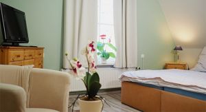 Schlafzimmer 2 im OG Hier finden Sie ein weiteres Doppelbett mit Nachttischschränkchen und -lampen. Ein Kleiderschrank und eine Kommode bieten Stauraum für Ihre persönlichen Sachen. Auch an eine kleine Sitzecke mit 2 Sesseln, Kinderstuhl, Tischchen und Flachbild-TV ist gedacht.
Der Raum ist mit Laminat und Teppichen ausgelegt, das Fenster verfügt über Verdunklungsvorhänge.
