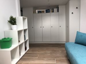 Blick im Durchgangszimmer auf den Kleiderschrank, Auszugscouch und Spielzeugregal.