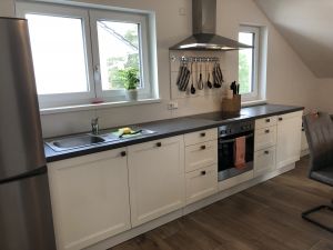 Unsere Einbauküche ist so eingerichtet, dass Sie sich problemlos in Ihrem Urlaub selber versorgen können. Daneben steht ein Esstisch, an welchem problemlos sechs Personen Platz nehmen können.