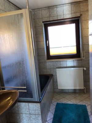 Badezimmer mit Duschwanne und WC