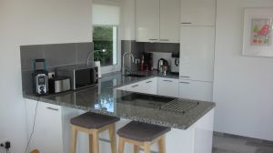 Offene Wohnküche mit Spülmaschine, Mikrowelle, Herd/Backofen, Kühlschrank, Tiefkühlschrank, Kaffeevollautomat, Kaffeemaschine, Wasserkocher und alles was man noch so braucht. Eine Waschmaschine und einen Trockner finden Sie außerhalb des Hauses im Nebengebäude auf dem Grundstück. Am direkt anschließenden Esstisch finden Sie neben den Stühlen auch eine gemütliche Sitzbank.