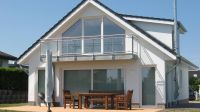 Das Haus Süd-Ost-Seite mit der Fensterfront vom Wohnzimmer. Davor die Terrasse mit dem Grill und der große eingezäunte Garten. Im Obergeschoss befindet sich die Galerie, bzw. das zweite Wohnzimmer mit klasse Meerblick, weiterem TV, gemütlicher Couch und hochwertigem 180er Schlafsofa mit verstellbaren Lattenrosten. Hier kann man es aushalten.; -) - Bild 1: Exklusives, hundefreundliches Ferienhaus mit klasse Meersicht, nahe Grömitz