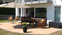 Die Terrasse am Haus Die große Terrasse mit direkt anschließendem Rasen. Genießen Sie hier Ihren Urlaub und lassen es sich gut gehen. Einen Grill finden Sie hier auch. Auf der zweiten Hochterrasse im Garten können Sie es sich im Strandkorb gemütlich machen, bei toller Seesicht. - Bild 7: Exklusives, hundefreundliches Ferienhaus mit klasse Meersicht, nahe Grömitz