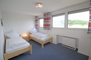 hat 2 Einzelbetten, Nachtschränkchen und einen Kleiderschrank.