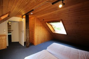 Der Einbau-Kleiderschrank ist im Doppelschlafzimmer auf der Empore. Aus dem Dachfenster hat man einen wunderbaren Blick ins Grüne.