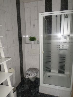 Duschbad am Schlafzimmer Toilette und Duschkabine sind auf der rechten Seite des Zimmers.