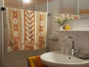 Badezimmer Die Badausstattung umfasst neben einer Dusche, Waschbecken und WC auch einen Badezimmerschrank sowie einen Föhn.