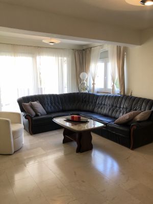 Wohnzimmer mit großer Couch sowie einem Fernseher