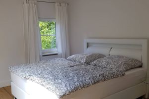Komfortables Doppelbett mit bequemen Federkernmatratzen und Kleiderschrank.