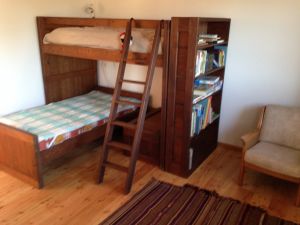 Neben dem massiven Doppelstockbett gibt es hier auch einen schönen Tisch, eine Sitzecke und ein Bücherbord