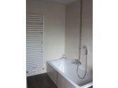 Das Bad besitzt eine Badewanne und eine ebenerdige Dusche.