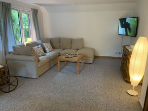 Wohnzimmer Esszimmer Couch TV Im Wohn- und Esszimmer findest Du eine gemütliche Couch, die zu einem Bett (140 x 200) ganz einfach umgebaut werden kann. Der große SMART TV an der Wand ist drehbar.
