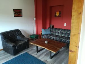 Wohnzimmer Das Wohnzimmer mit Zugang zum Balkon ist halb offen zur Küche. Sofa ein Sessel und Fernseher sind in diesem Zimmer