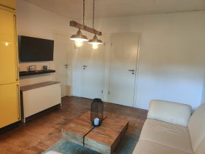 Das Wohnzimmer ist mit einem Fernseher und einem Nachtspeicherofen ausgestattet. Hier findet auch ihr vierbeinige Freund einen Platz.