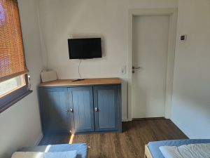 Das Schlafzimmer 2 verfügt über zwei Einzelbetten (80x200 cm), einem Fernseher, einer Kommode und einer Infrarotheizung.