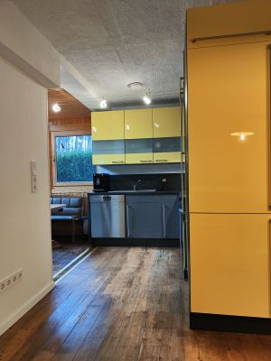 Von der Couch aus können Sie ebenfalls in die offene Küche schauen. Zwei weitere innenliegende Fenster bieten natürlichen Lichteinfall.