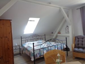 Wohn-Schlafzimmer Dachfenster mit Verdunklungsrollo. Bei offenem Rollo bietet sich ein schöner Blick über die Dächer von Pilsum zur Kirche.