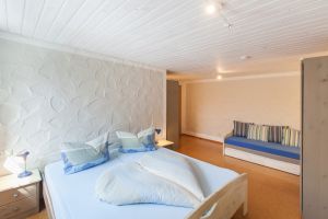 Elternschlafzimmer In diesem Schlafzimmer steht ein Doppelbett und eine Bettcouch. Auch hier gibt es einen Rollladen am Fenster.