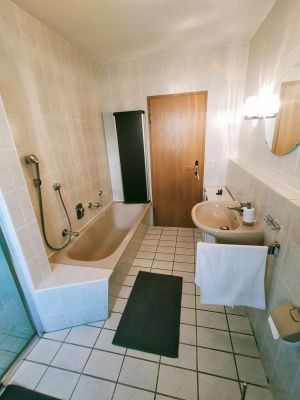 Das Tageslicht Bad ist gut ausgestattet mit WC - Waschbecken - Spiegel, sowie Vorratsschränken in denen ein kleines Kontingent an Klopapier und auch ein kleiner Fön vorhanden sind.
Neben der Dusche gibt es noch eine Wanne zum entspannen. Dieser Raum verfügt über eine Fussbodenheizung.