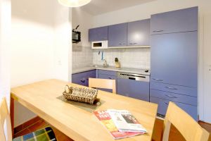 Gut ausgestattete Einbauküche mit großem Esstisch.