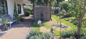 Gepflasterte Terrasse mit Garten und Sitzgelegenheit