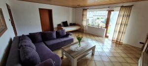Das Wohnzimmer verfügt über eine Schlafcouch , sowie ein weiteres Bett, Fernseher und direkter Zugang zur Terrasse