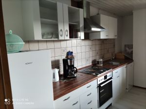 Die Küche ist voll ausgestattet.
Ein Tisch mit vier Stühlen steht zum Essen bereit.
