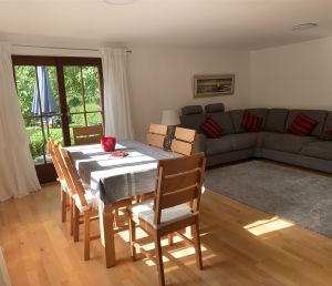 Der abgeschlossene Wohnraum besitzt eine Essgruppe mit 6 Stühlen, ein Ecksofa mit 2 Beistelltischen, einem Sideboard mit Fernseher.