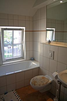 Badezimmer mit Badewanne und Duschabtrennung