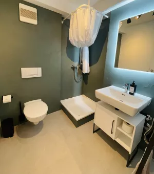 Innenliegendes Badezimmer mit Wc, Dusche und Waschbecken.