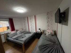 Schlafzimmer mit TV. Ein Doppel- und ein Einzelbett.