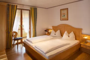 Schlafzimmer mit Doppelbett, Kleiderschrank und Nachttisch, teilweise mit Kofferbock
