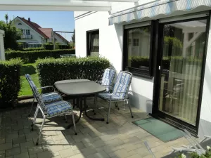 Die überdachte Terasse ist möbiliert. Eine Markiese spendet Schatten