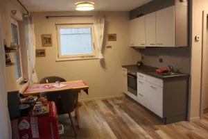 Essbereich mit Blick in den Garten/die Berge. Die Küche ist voll ausgestattet mit allem, was im Urlaub benötigt wird. Fondue-Caquelon oder Racletteofen stehen genauso zur Verfügung wie Kaffeemaschine, Toaster oder Wasserkocher
