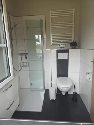 Elegantes Badezimmer mit ebenerdiger Dusche, Spiegelschrank und Fußbodenheizung.