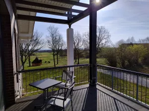 Den Sonnenaufgang genießen. Für den geschützten Balkon stehen ein Tisch, zwei Stühle und zwei Sonnenliegen bereit.