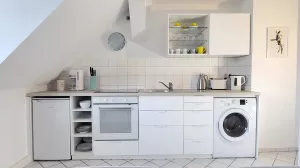 moderne Küchenzeile mit Herd, Backofen, Waschmaschine. Voll mit allen Küchenutensilien ausgestattet