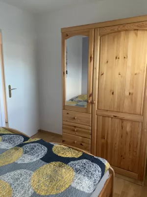 Schlafzimmer mit zwei Betten, Nachtschränken und Kleiderschrank