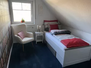 Romantisches Einzelzimmer mit Bett, Schrank und Sitzgelegenheit