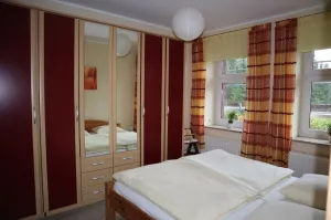 mehrtüriger Kleiderschrank mit zusätzlichen Schubladen im großen Schlafzimmer, welcher viel Stauraum bietet