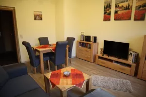 Wohnzimmer mit Essecke,Schränken,Fernseher und Radio mit CD-Player,es sind weiterhin eine Auswahl für große und kleine Gäste vorhanden