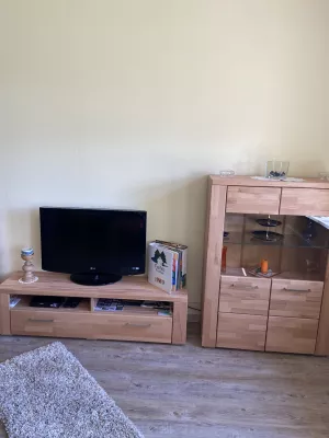 Wohnzimmerschränke mit SAT- Fernseher,in den Schränken befinden sich eine große Auswahl an Gesellschaftsspielen für jedes Alter sowie Puzzle und weitere Spielsachen für große und kleine Kinder