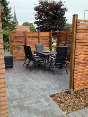 Gemütliche Terrasse mit Gartenstühlen und Grill