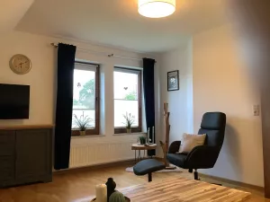 Wohnzimmer mit Fernsehsessel und Blick nach Draußen