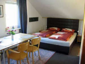 Wohnliche Atmosphäre mit Blick vom Essbereich auf das Boxspringbett 200 x 180 cm.