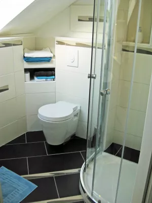 Separates, geräumiges Duschbad im Ronja Apartment. Ein großes Schrägfenster sorgt für reichlich Tageslicht und gute Lüftung.